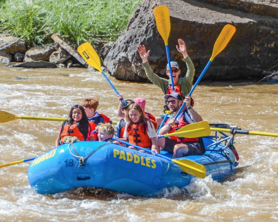 A group of sixth graders rafting down a river